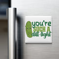 A refrigerator door with a humorous magnet that reads "you're such a dill-light".