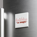 A white square magnet with the text "kindness is magic" in a cursive font.