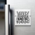 A white refrigerator magnet with the text "GIVE thanks AND BE grateful" written on it.