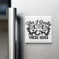 A refrigerator door with a magnet that says "Yes I Really Do Need All These Dogs" in a stylized font.