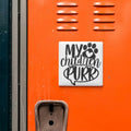 a close-up of an orange surface with a sticker or sign that says "My children purr" in black text.
