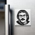 A black and white illustration of a man's face with glasses is displayed on a refrigerator door.