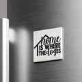 A white magnet with the text "home is where the dogs are" on it is attached to a metallic surface.