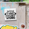 a sticker with the text "Sorry I HAVE plans with MY dog" on a concrete surface.
