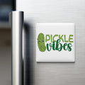 a refrigerator with a magnet that says "Pickle Vibes" in a playful, cartoonish font.