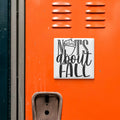 a close-up of an orange surface with a white sign that reads "NOTS ABOUT FALL".