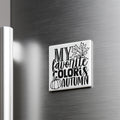 A white square magnet with black text and graphics on a metallic surface.