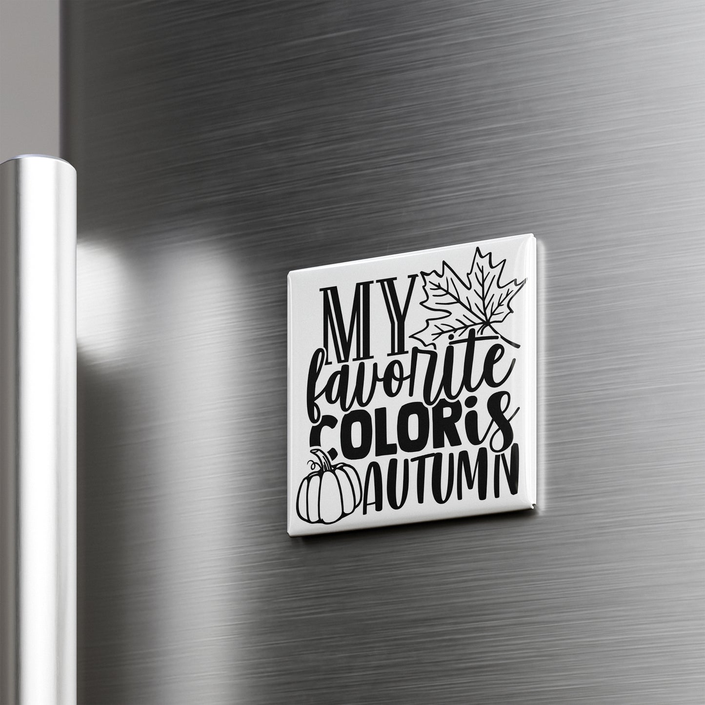 A white square magnet with black text and graphics on a metallic surface.