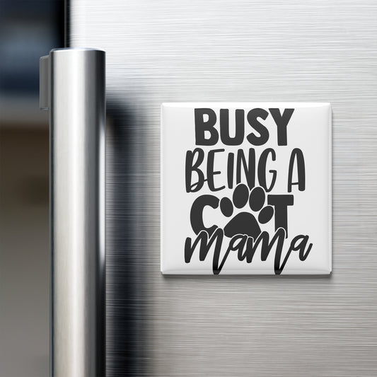 A white refrigerator magnet with the text "BUSY BEING A COT MAMA" printed on it.