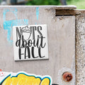 a sticker with the text "NOTS about FALL" on a concrete surface.