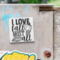 a sticker with the text "I LOVE fall MOST of all" on a concrete surface.