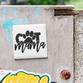 a sticker with the word "COT" and a paw print, mounted on a concrete surface.