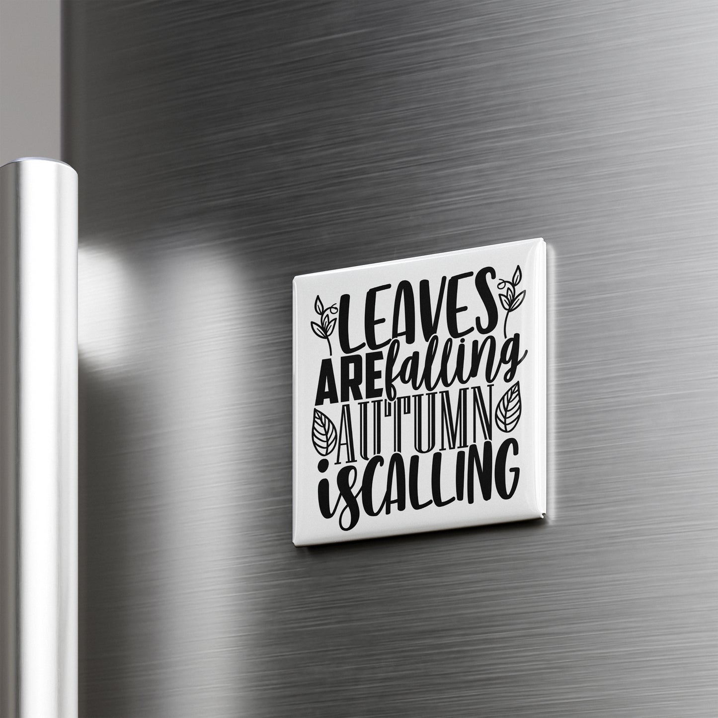 A white square magnet with black text that says "LEAVES AREFALLING AUTUMN IS CALLING" is mounted on a metallic surface.