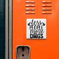 a sign with the text "less people more dogs" on an orange surface.