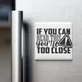 a refrigerator with a white magnet on its surface that contains the text "IF YOU CAN READ THIS YOU'RE TOO CLOSE".