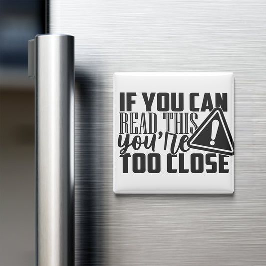 a refrigerator with a white magnet on its surface that contains the text "IF YOU CAN READ THIS YOU'RE TOO CLOSE".